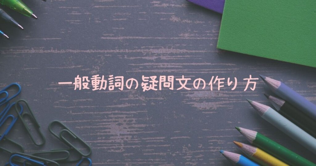 写真の左上にはボールペン、右上には緑と紫の紙、右下には色鉛筆、左下にはクリップがあります。文法のが説明のため、学習机をイメージする画像を選びました。