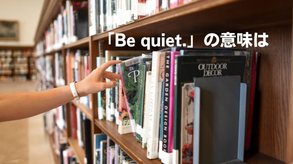 静かな図書館で一冊の本を取ろうとしている手が写っています。「Be quiet.」という英文の意味を分かりやすくするため、図書館のように静かな環境の写真を使いました。