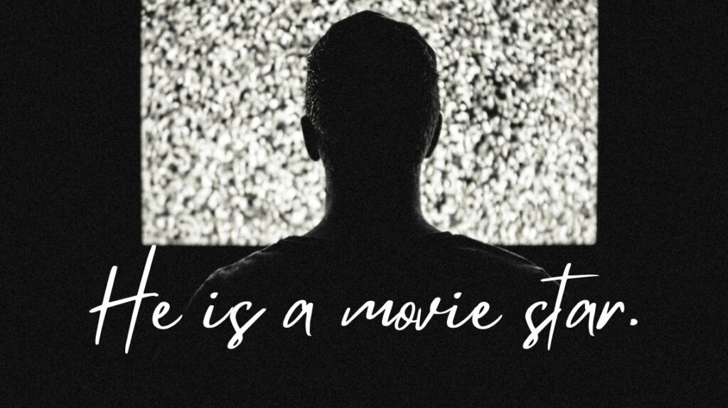 一人の男性が映画館のような暗い場所でスクリーンを見ています。He is a movie star.という英文を説明するための画像です。